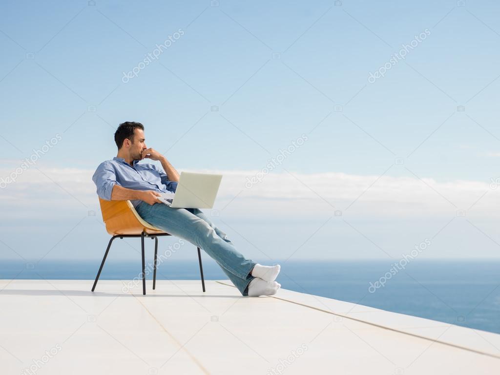 Relaxed young man at home on balcony