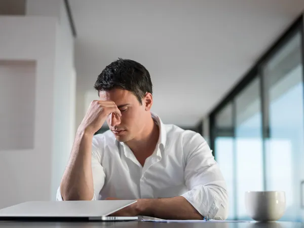 Gefrustreerde jonge zakenman werkt op laptop computer thuis — Stockfoto