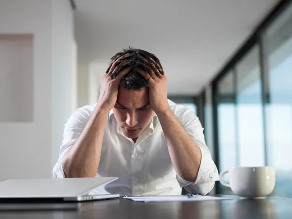 Frustrierter junger Geschäftsmann arbeitet zu Hause am Laptop — Stockfoto