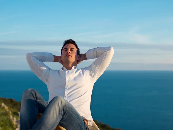 Relaxed young man at home on balcony — Stock Photo, Image