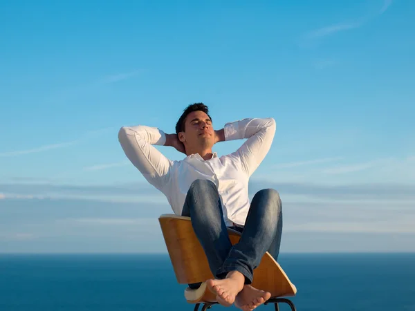 Relaxed young man at home on balcony — Stock Photo, Image