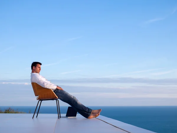 Entspannter junger Mann zu Hause auf Balkon — Stockfoto