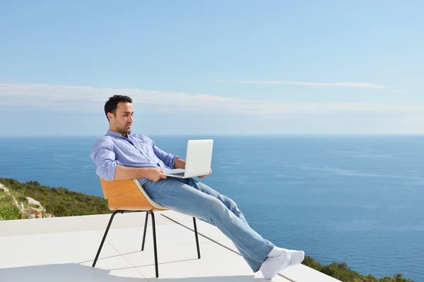 Man op balkon met computer — Stockfoto