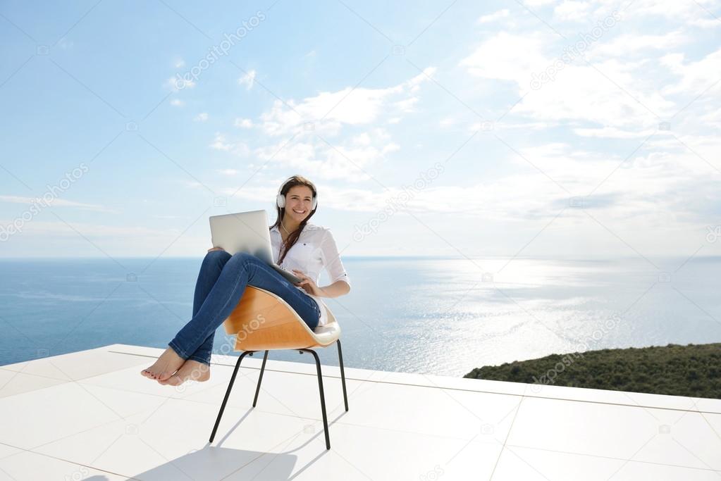 Woman working on laptop outdoors