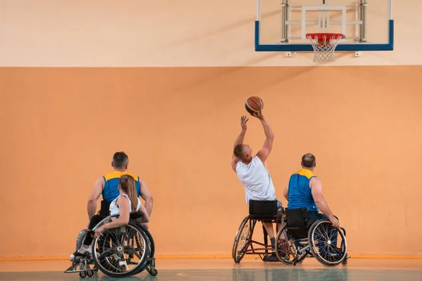 Gehandicapten Oorlog veteranen gemengd ras en leeftijd basketbal teams in rolstoelen spelen van een trainingswedstrijd in een sporthal. Rehabiliteits- en integratieconcept voor gehandicapten — Stockfoto