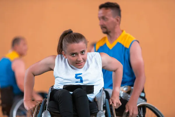 Een jonge vrouw die rolstoelbasketbal speelt in een professioneel team. Gendergelijkheid, het concept sport met een handicap. — Stockfoto