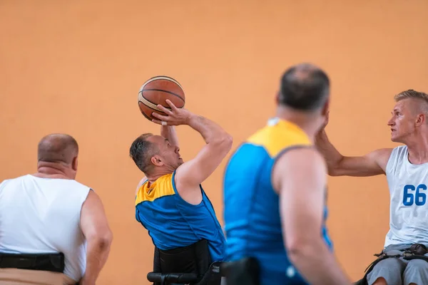 Ветераны войны инвалидов смешанные расовые и возрастные баскетбольные команды в инвалидных колясках играют тренировочный матч в спортзале. Концепция реабилитации и включения инвалидов — стоковое фото