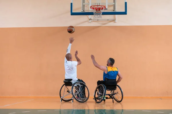 Een foto van een oorlogsveteraan die basketbal speelt met een team in een moderne sportarena. Het concept sport voor mensen met een handicap — Stockfoto