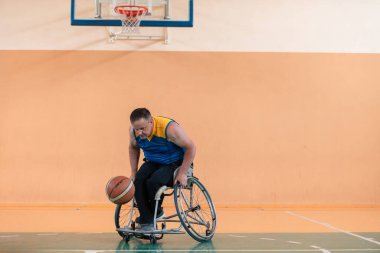 Engelli savaş gazileri ve tekerlekli sandalyeli yaş basketbol takımları spor salonunda antrenman yapıyorlar. Özürlülerin rehabilitasyonu ve kapsama konsepti
