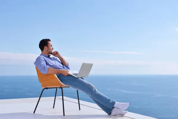 Mannen på balkongen med dator — Stockfoto