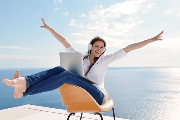 Frau arbeitet mit Kopfhörer am Laptop — Stockfoto