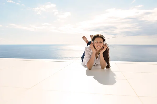 Fille écouter de la musique sur écouteurs blancs — Photo