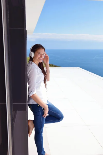 Girl listening music on white headphones — Stock Photo, Image