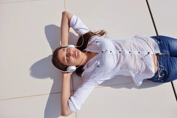 Дівчина слухає музику на білих навушниках — стокове фото