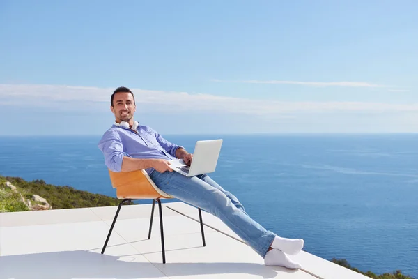 Man op balkon met computer — Stockfoto