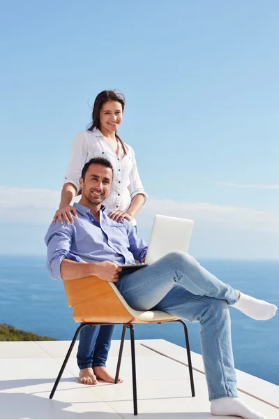 Casal na varanda com computador — Fotografia de Stock