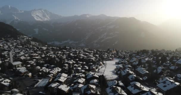 Flygfoto av en by i Schweiz som var täckt av snö på ett populärt resmål för skidåkare — Stockvideo