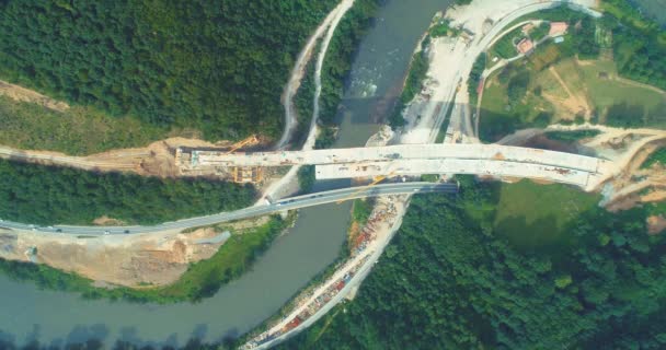 Byggande av vägbro. Flygfoto över bron konstruktion över motorvägen. Utsikt från ovan landsväg reparation. Bygga broar på förortsvägen — Stockvideo