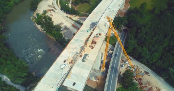道路橋の建設。高速道路上の橋の建設の空中ビュー。高速道路の道路の修復の上からの眺め。郊外道路に橋を架ける — ストック動画