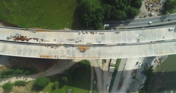 Строительство автомобильного моста. Вид с воздуха на строительство моста над автомагистралью. Вид сверху на ремонт дороги. Строительство мостов на пригородной дороге — стоковое видео