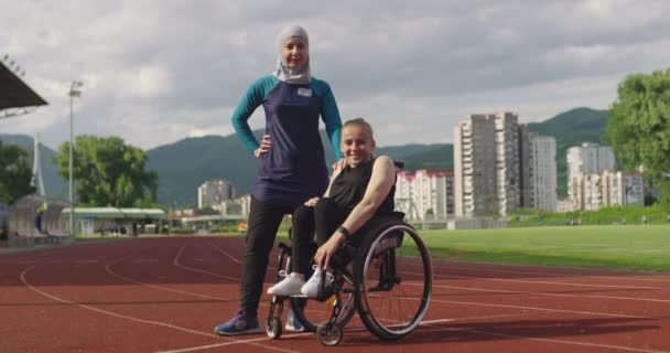 Héroe retrato de tiro de personas con discapacidad deportiva whit entrenador femenino usando hijab después de entrenar en pista de deportes de atletismo. — Vídeos de Stock
