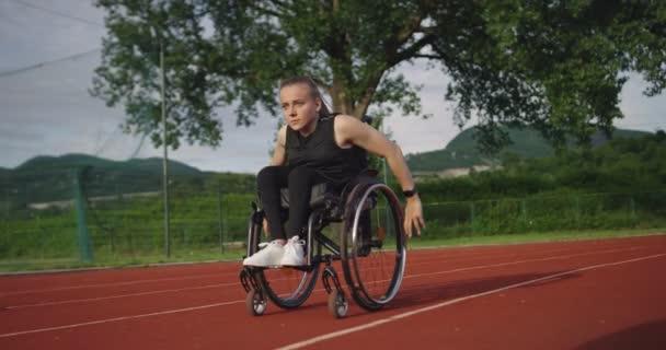 A female person with disabilities riding a wheelchair on a training track — Stock Video