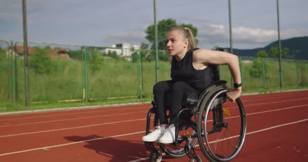 Eine Frau mit Behinderungen im Rollstuhl auf einem Trainingsplatz — Stockvideo
