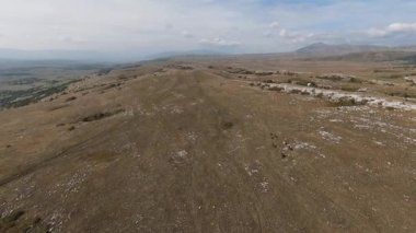 FPV İHA 'sı bozkırda dört nala koşan büyük bir vahşi at sürüsüyle uçuyor.