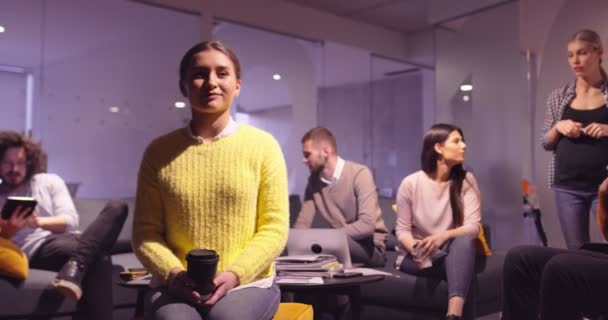 Retrato de una joven empresaria como líder de equipo mirando a la cámara y sonriendo. Compañeros multiétnicos en segundo plano Equipo diverso en la moderna oficina de inicio de espacios abiertos. Foto de alta calidad — Vídeo de stock