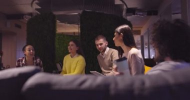 Modern bir açık alanda çalışan Müslüman bir kadın takıma bir sunum yapıyor. Orta Doğulu Arap iş kadını yaratıcı bir ofiste. Ekip toplantısında tekerlekli sandalyedeki engelli iş adamı 