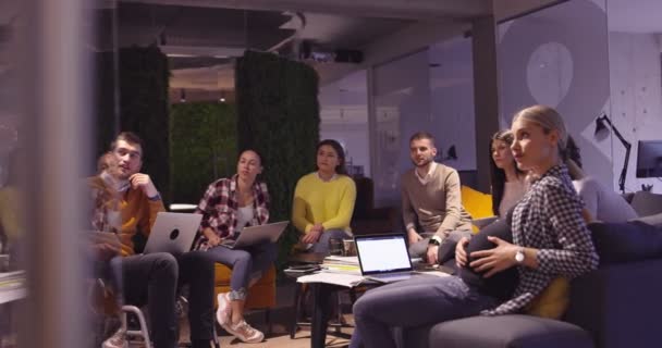 O femeie musulmană într-un birou modern de coworking în spațiu deschis care oferă o prezentare echipei. Femeia de afaceri arabă din Orientul Mijlociu în biroul de startup-uri creative. Un om de afaceri cu handicap într-un scaun cu rotile la întâlnirea de echipă — Videoclip de stoc