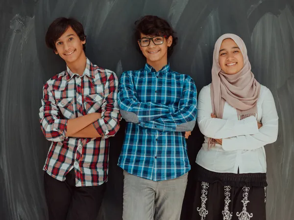 Um retrato de um grupo de adolescentes árabes com braços cruzados em frente a um conselho escolar. O conceito de educação moderna e bem sucedida — Fotografia de Stock