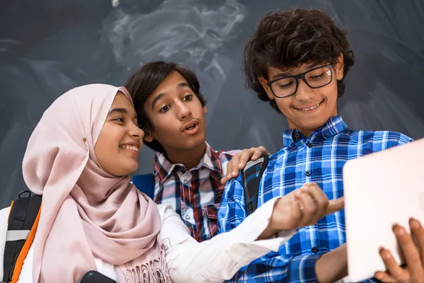 Arap gençlik takımı, öğrenci grubu dizüstü bilgisayar ve tablet bilgisayar online sınıf eğitimi kavramında birlikte çalışıyor — Stok fotoğraf