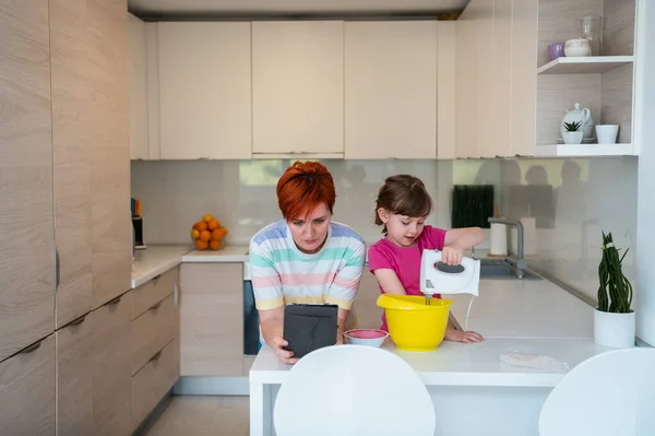 Маленькая девочка и мама делают вкусный торт в семье Китен весело проводили время дома — стоковое фото