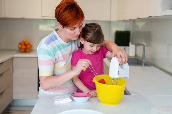 Grappig klein meisje helper spelen met deeg op zijn handen leren kneden helpt volwassen moeder in de keuken, gelukkig schattig dochtertje en ouder moeder veel plezier koken koekjes. — Stockfoto