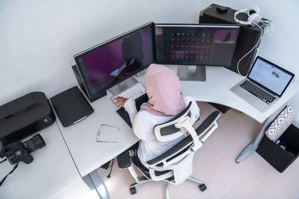여성 아랍어 창 작업자가 가정 사무실에서 듀얼 스크린 모니터가 있는 데스크 탑 컴퓨터에서 일하고 있습니다. 선택 초점 — 스톡 사진