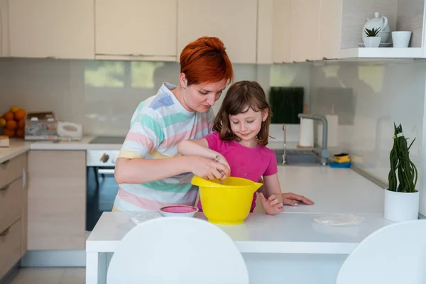 有趣的小女孩帮手手拿着面团玩，学着揉捏，帮妈妈在厨房里，快乐可爱的小女儿和妈妈在厨房里做饼干. — 图库照片