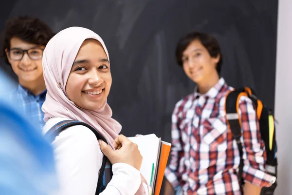 Adolescenti arabi, studenti ritratto di gruppo contro lavagna nera indossando zaino e libri a scuola.Focus selettivo — Foto Stock