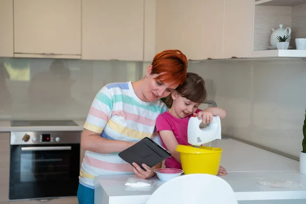 Küçük kız ve anne, Kithen ailesinde pasta yapıyor. Evde eğleniyorlar. — Stok fotoğraf