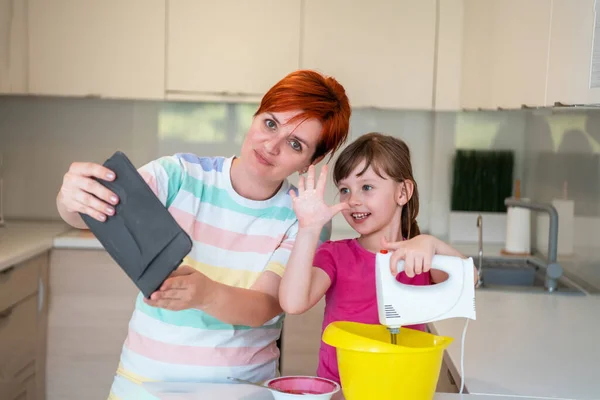 Liten flicka och mamma gör tastz tårta i kithen familj att ha kul hemma — Stockfoto