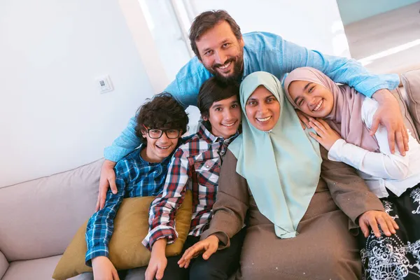 Portretfoto van een Arabische moslim familie zittend op een bank in de woonkamer van een groot modern huis. Selectieve focus — Stockfoto