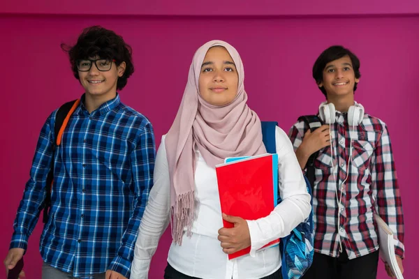 Een groep Arabische tieners, een studententeam dat vooruitloopt op de toekomst en terug naar school gaat met het concept van een roze achtergrond. Het concept van succesvol onderwijs voor jongeren. Selectieve focus — Stockfoto