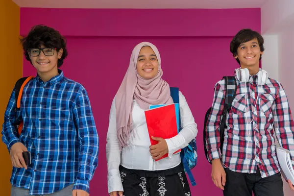 Un grupo de adolescentes árabes, un equipo de estudiantes caminando hacia el futuro y de vuelta a la escuela el concepto de un fondo rosa. El concepto de educación exitosa para los jóvenes. Enfoque selectivo — Foto de Stock