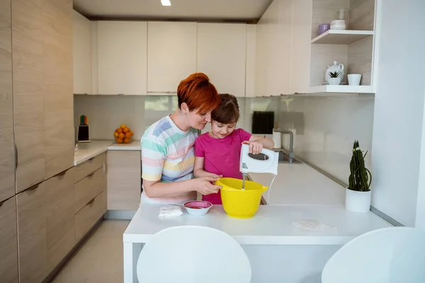 Rolig liten flicka hjälpare leka med deg på händerna lära sig att knåda hjälper vuxna mamma i köket, glad söt liten dotter och förälder mamma har kul matlagning kakor. — Stockfoto