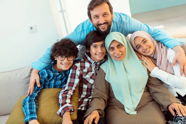 Portretfoto van een Arabische moslim familie zittend op een bank in de woonkamer van een groot modern huis. Selectieve focus — Stockfoto
