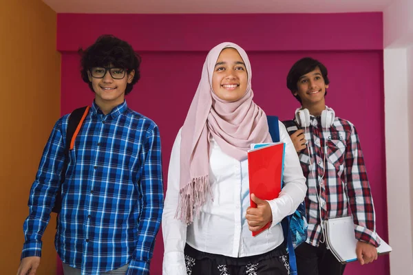 Un gruppo di adolescenti arabi, una squadra studentesca che cammina verso il futuro e torna a scuola il concetto di sfondo rosa. Il concetto di educazione di successo per i giovani. Focus selettivo — Foto Stock