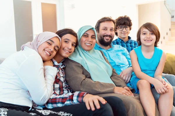 Portretfoto van een Arabische moslim familie zittend op een bank in de woonkamer van een groot modern huis. Selectieve focus — Stockfoto