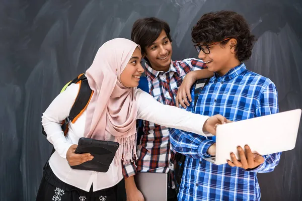 Gruppo di adolescenti arabi, gruppo di studenti che lavorano insieme su computer portatile e tablet concetto di istruzione in aula online — Foto Stock