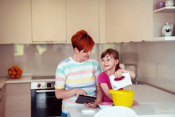 Bambina e mamma fare torta tastz in famiglia kithen divertirsi a casa — Foto Stock