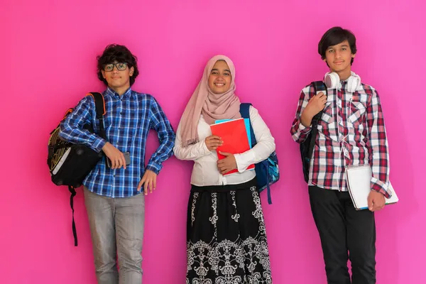 Un grupo de adolescentes árabes, un equipo de estudiantes caminando hacia el futuro y de vuelta a la escuela el concepto de un fondo rosa. El concepto de educación exitosa para los jóvenes. Enfoque selectivo —  Fotos de Stock